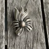 Tradera Broscher<Brosch i silver stämplad, som en blomma