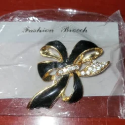 Tradera Broscher<Ett vackert broch svart/guldfärgat med strass oanvänt