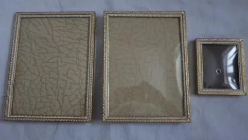 Tradera Gamla fotoramar guld o vitt med vackert mönster ram metall lätt kupat glas Jyden> Ramar